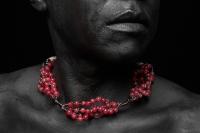 photograph of lower part of face with red necklace