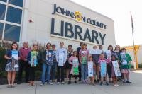 A group of children and adults standing outside the Central Resource Library