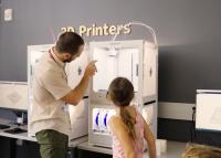 MakerSpace patrons looking at the 3D printer