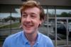 Jack Vandeleuv red-haired, smiling young man in a blue collared shirt
